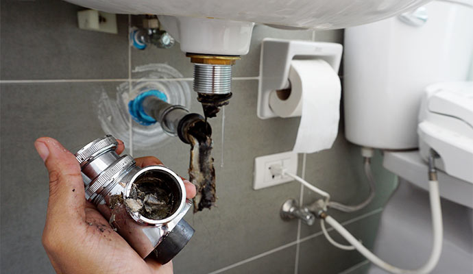 a person cleaning a clogged water pipe