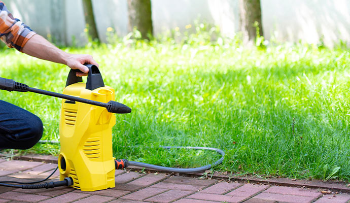 man using electric spray in the garden