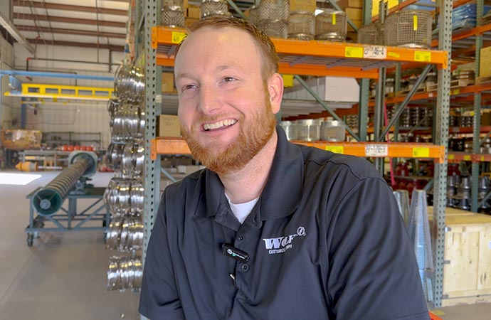 Warehouse worker in black polo shirt, wolf pumps stored besides